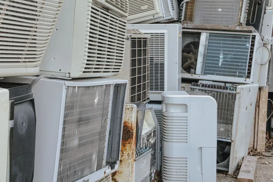A pile of old air conditioner units, before